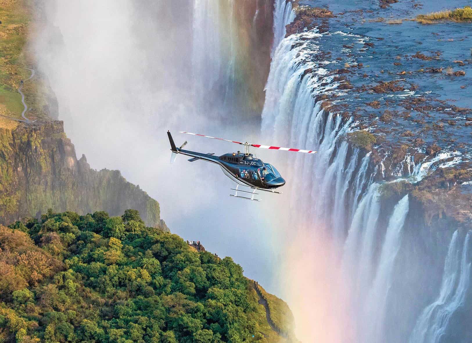Helicopter flight over Victoria Falls with a rainbow in the mist, Zimbabwe